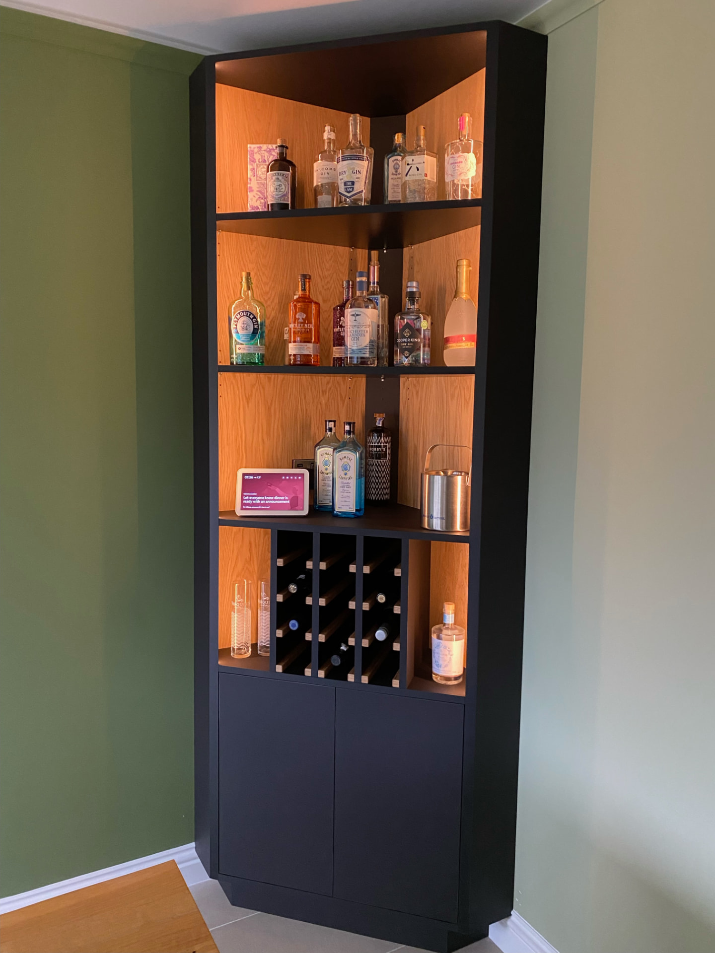 Bespoke corner drinks cabinet in black with oak-lined lit shelving and a wine rack
