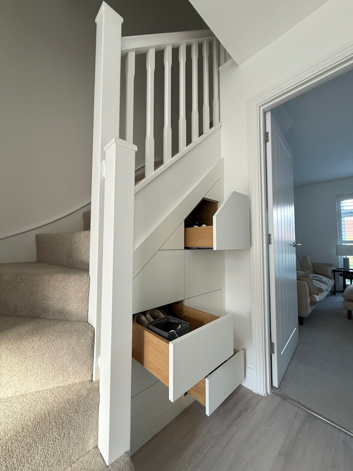 Understairs storage with push-to-open drawers and oak-lined interiors